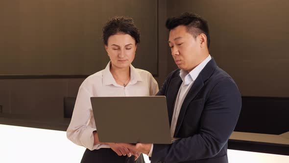 Korean Man Showing Commercial Offer on Laptop Discuss Contract Details