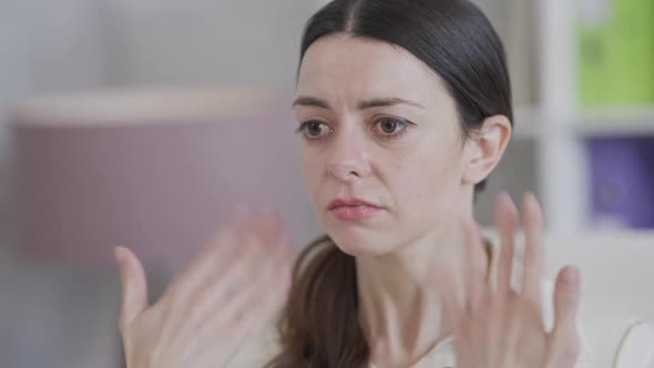 Closeup of Stressed Crying Slim Young Woman with Big Brown Eyes Calming Down Shaking Hands at Face