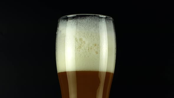 Rotate the light beer into the glass. Cold light beer in a glass with water drops. Craft beer