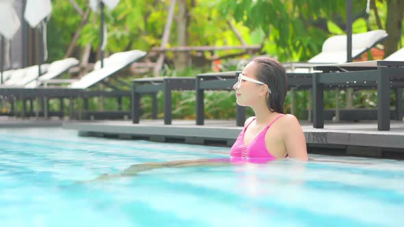 Young asian woman enjoy around outdoor swimming pool for leisure