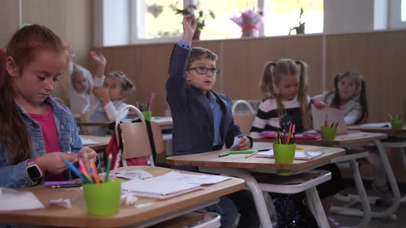 Smart Schoolboy Raising Hand To Answer Question