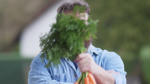 Happy farmer or seller with bunch of fresh carrots