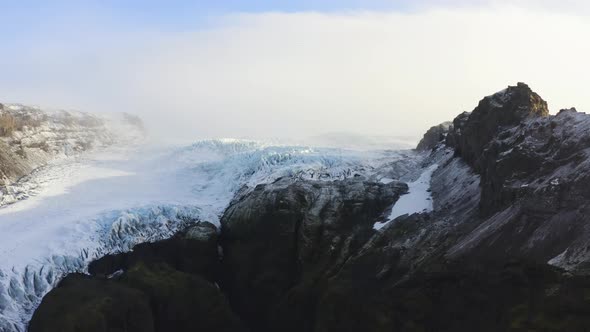 Drone Towards Black Mountain Side And Frozen Glacier Of Vatnajokull