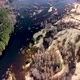 Aerial view of the river between the pines. Flying over a winding riverbed surrounded by treetops - VideoHive Item for Sale