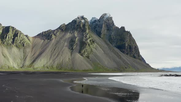 Drone Of Man On Black Beach Under Vestrahorn Mountain