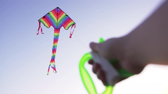 Hand of Young Woman Raises a Kite in a Sky