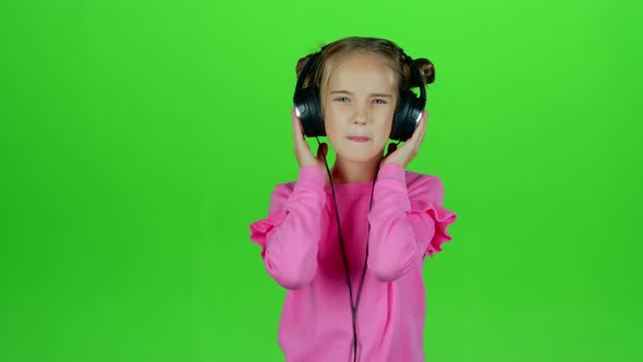 Baby Listens To the Music in the Headphones. Green Screen. Slow Motion