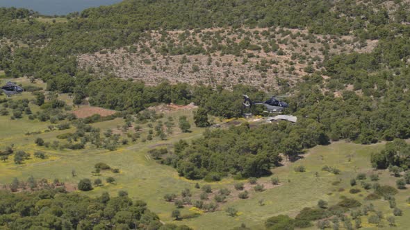 Following Shot of Private Helicopters Flying Over a Hill Near Loutraki Greece