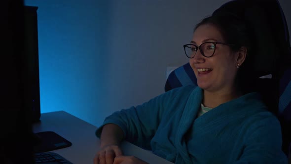 Woman Watches TV Series Via Computer with Bright Smile