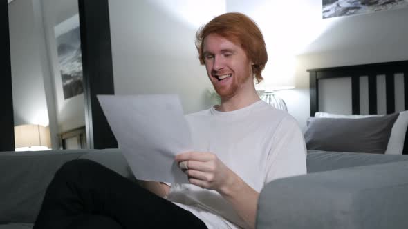 Redhead Man Excited after Reading Documents