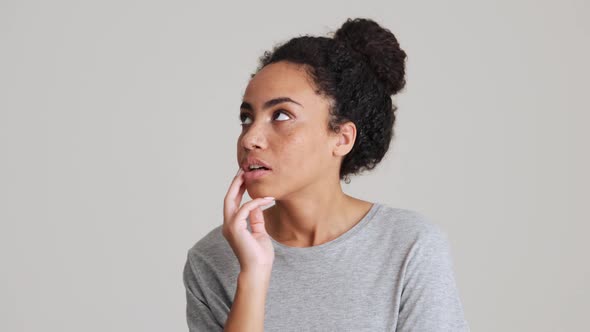 Bored African woman in t-shirt rolling her eyes