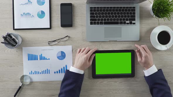 Businessman Working on Tablet With Green Screen, Top View of Workplace