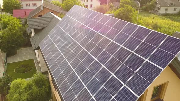 Aerial top view of new modern residential house cottage with blue shiny solar photo voltaic panels