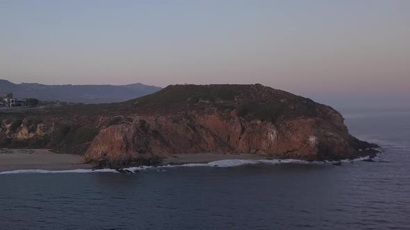 AERIAL: Flight Over Malibu, California View of Beach Shore Line Pacific Ocean at Sunset with