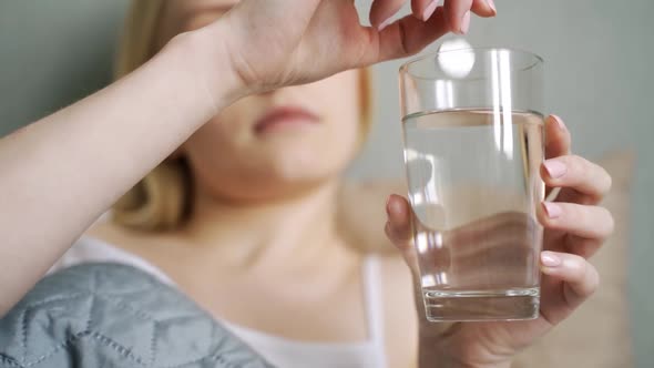 Close Up of Effervescent Tablet Dissolves Into Glass of Water