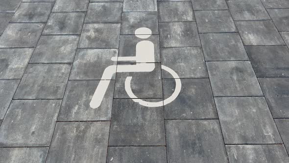 Large Disabled Parking Lot White Sign Over Brick Pavement