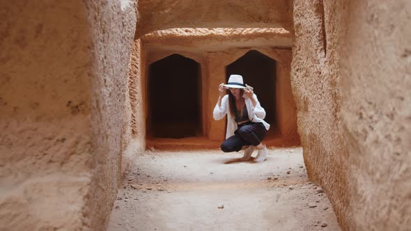 Woman Using Gadgets While Examining Ancient Temple