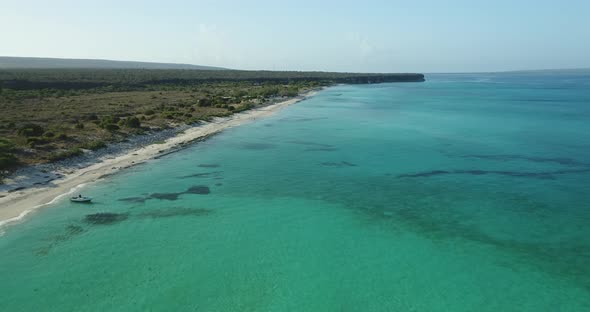 Low-altitude drone flight in the jaragua national park, highlighting the crystal clear water on a be