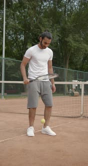 Unrecognizable Man Bouncing a Ball on Tennis Racket