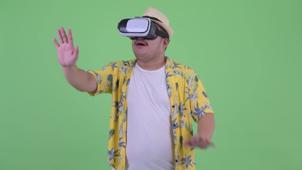 Happy Young Overweight Asian Tourist Man Using Virtual Reality Headset
