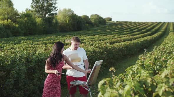 Cheerful Artists' Couple Creatives a Landscape and Talks in Bush Field