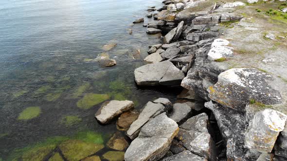 Drone flying over rocky coastline of Asunden Raukfield, birds eye view