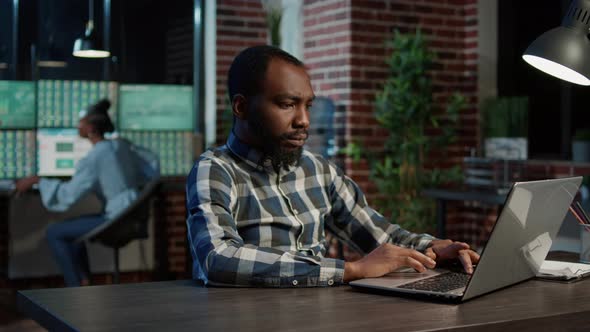 Financial Analyst Working at Night with Stock Exchange Numbers