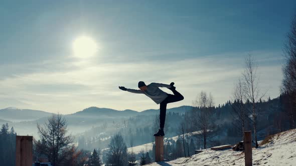 Traveler Practicing Yoga in the Winter Mountains and Enjoying Life