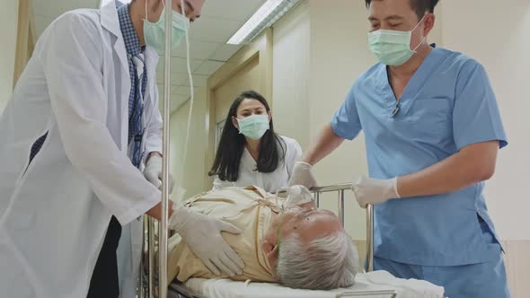 Group of doctor, nurse and surgeon moving seriously injured patient lying on a stretcher in hospital