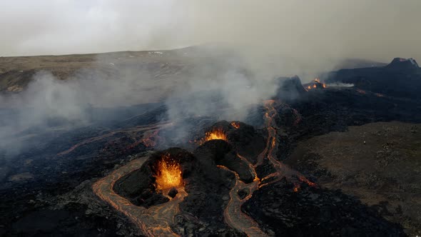 Flying over exploding lava fountains, in middle of smoky wild - Aerial drone