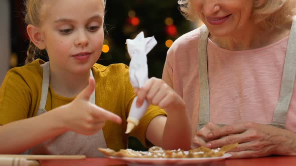 Granny and Grandchild Decorating Gingerbreads With Icing Sugar, Happy Holidays