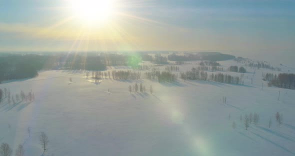 Aerial View of Cold Winter Landscape Arctic Field Trees Covered with Frost Snow Ice River and Sun