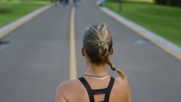 Female Jogger Training on Running Surface in Park. Woman Exercising Outdoors