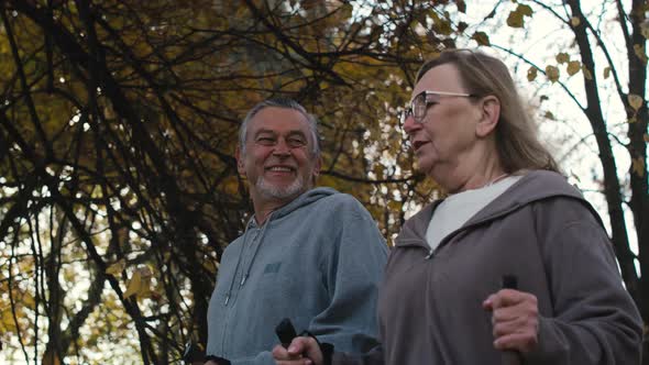 Caucasian senior couple nordic walking in the park. Shot with RED helium camera in 4K