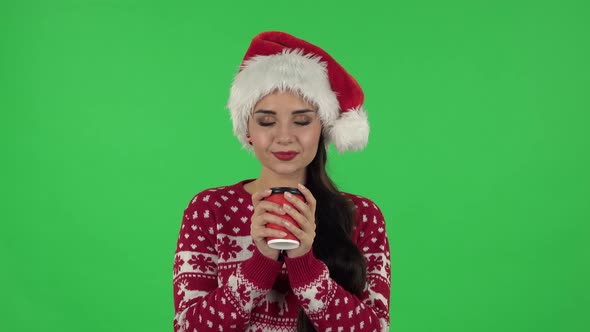 Portrait of Sweety Girl in Santa Claus Hat Is Enjoying Coffee. Green Screen