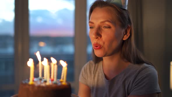 Happy Excited Woman Making Cherished Wish and Blowing Candles on Holiday Cake Celebrating Birthday