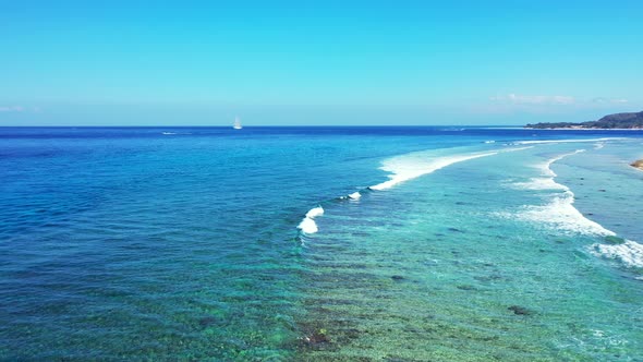 White waves foaming over rocky seabed and corals blending with calm clear water of turquoise lagoon