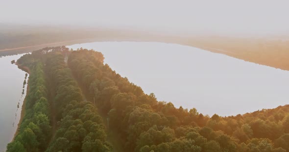 An Aerial View of the Forest Lake in a Foggy Morning Mist During the Morning Sunrise