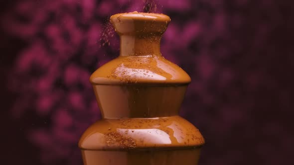 Chocolate Fountain Isolated on Blurry Purple Background