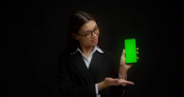 Business Lady in Glasses Shows Vertical Green Phone Screen for Copying