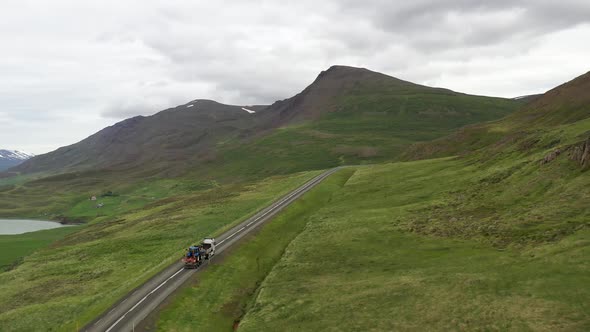 Semi truck driving through mountains in Iceland with drone video following along.