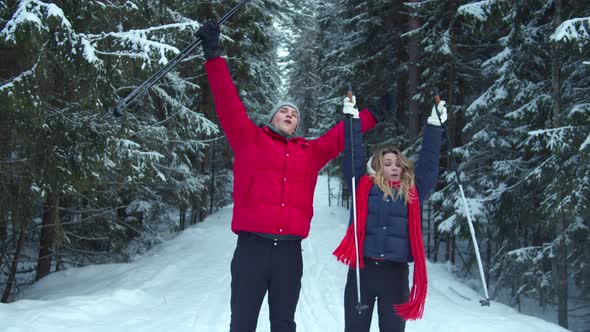 Two Skiers Rejoice and Raise Their Hands Victoriously