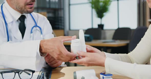 Doctor Giving Medicine to Female Patient During Her Visit to Clinic Center