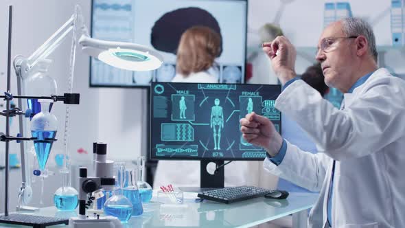 Adult Researcher in Modern Center Looking at a Sample Through a Magnifying Glass