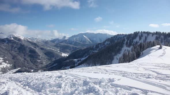 Camera pans left to right to show skier photographing mountain scene