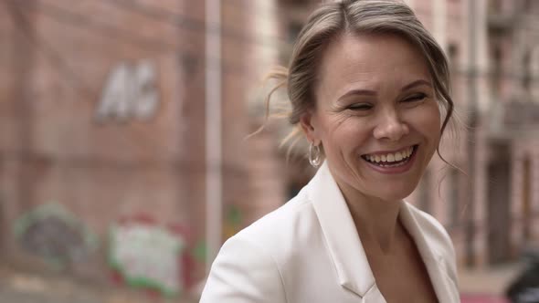 an Attractive Romantic Woman in White Clothes Against the Background of the City