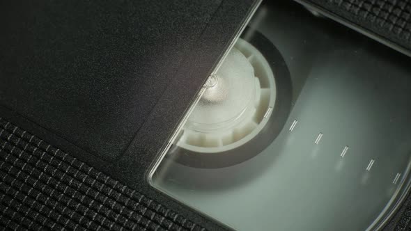 The Right Side of the VHS Cartridge at an Angle. a Film Reel Spins in a Small Cassette Window