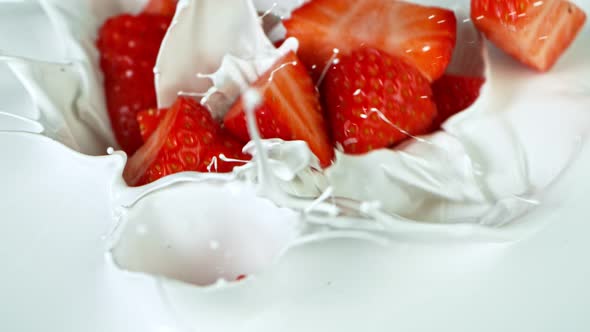 Super Slow Motion Shot of Fresh Strawberries Falling Into Cream at 1000Fps.