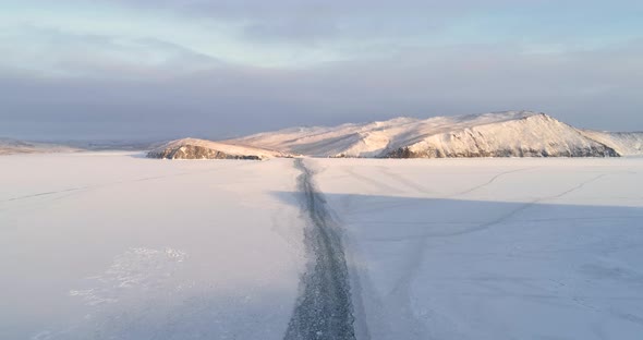 Drone Flies Over the Trail Left by a Ship on the Ice of a Frozen Lake Baikal