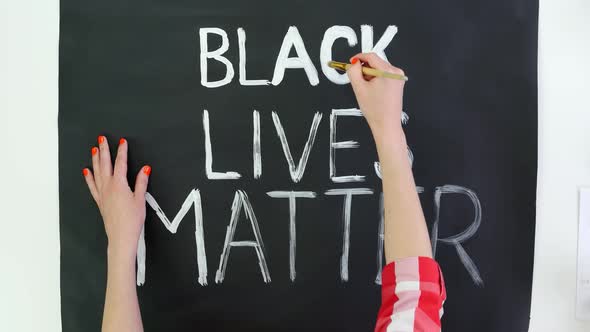 Timelapse. Close-up, Hand Writes Slogan - Black Lives Matter - with Brush, Using White Paint on